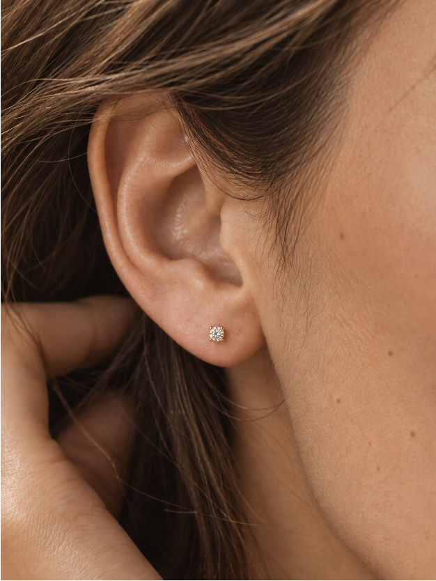 Detalle de pendiente solitario con diamante lab en oro amarillo 18K puesto en oreja – Mimmo Jewels